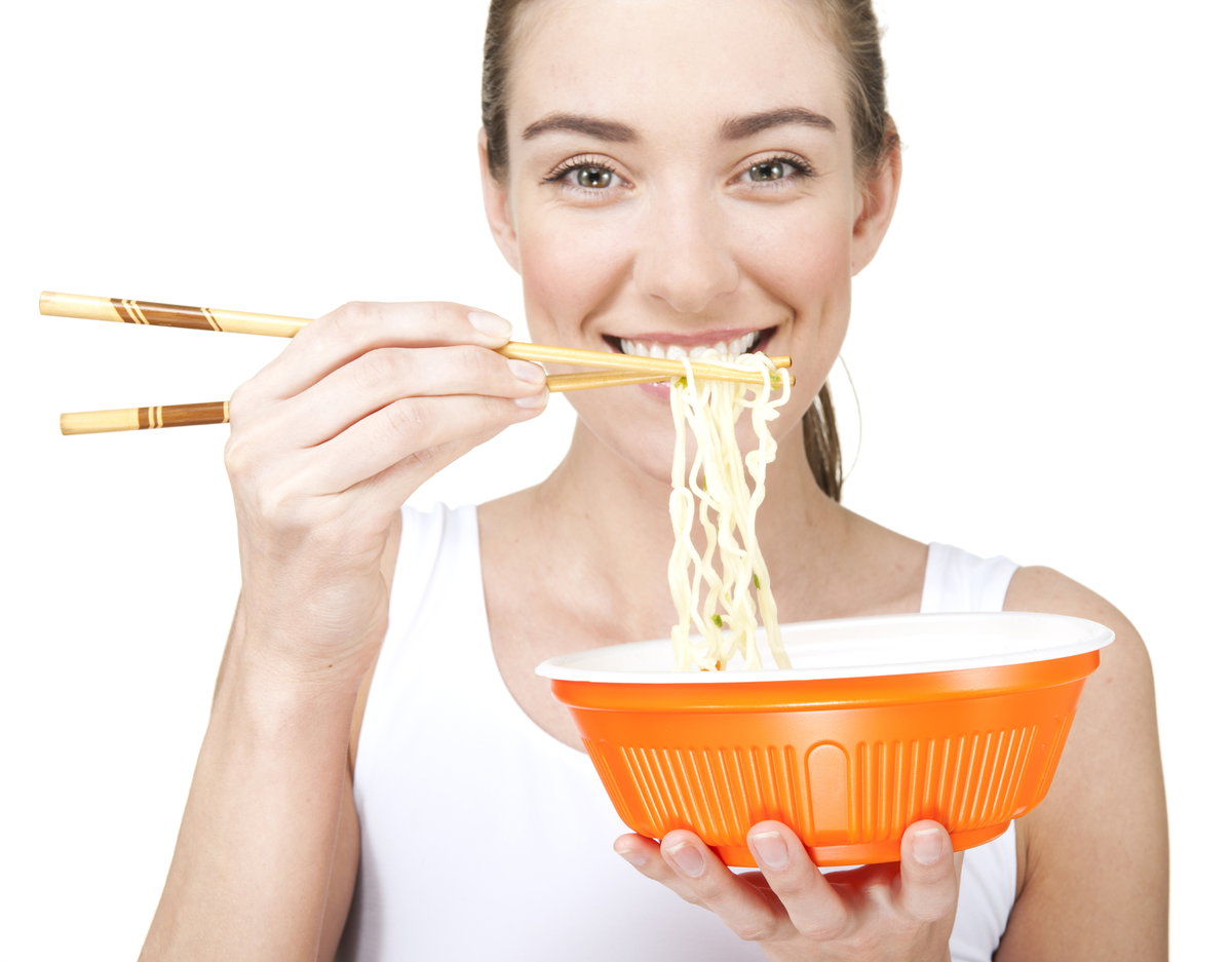 Frau isst Ramen mit Stäbchen