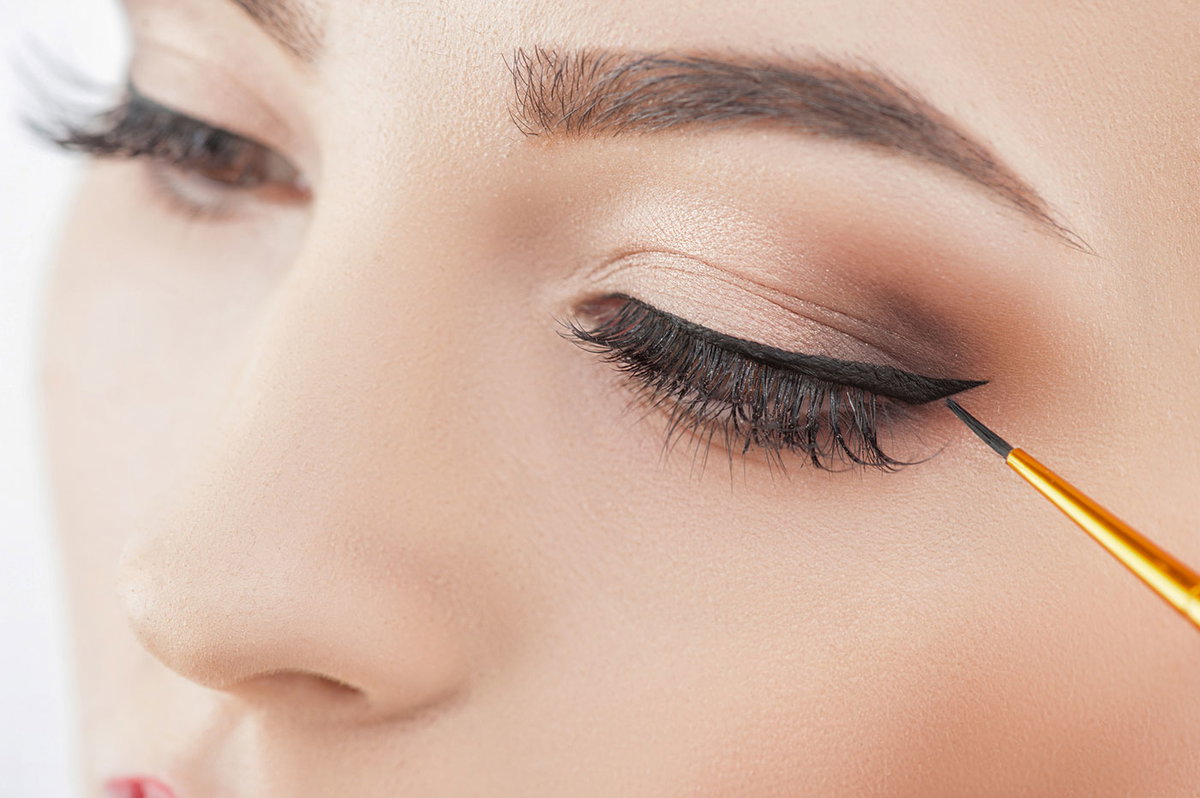 Ein Lidstrich mit Eyeliner lässt die Wimpern optisch dichter wirken.