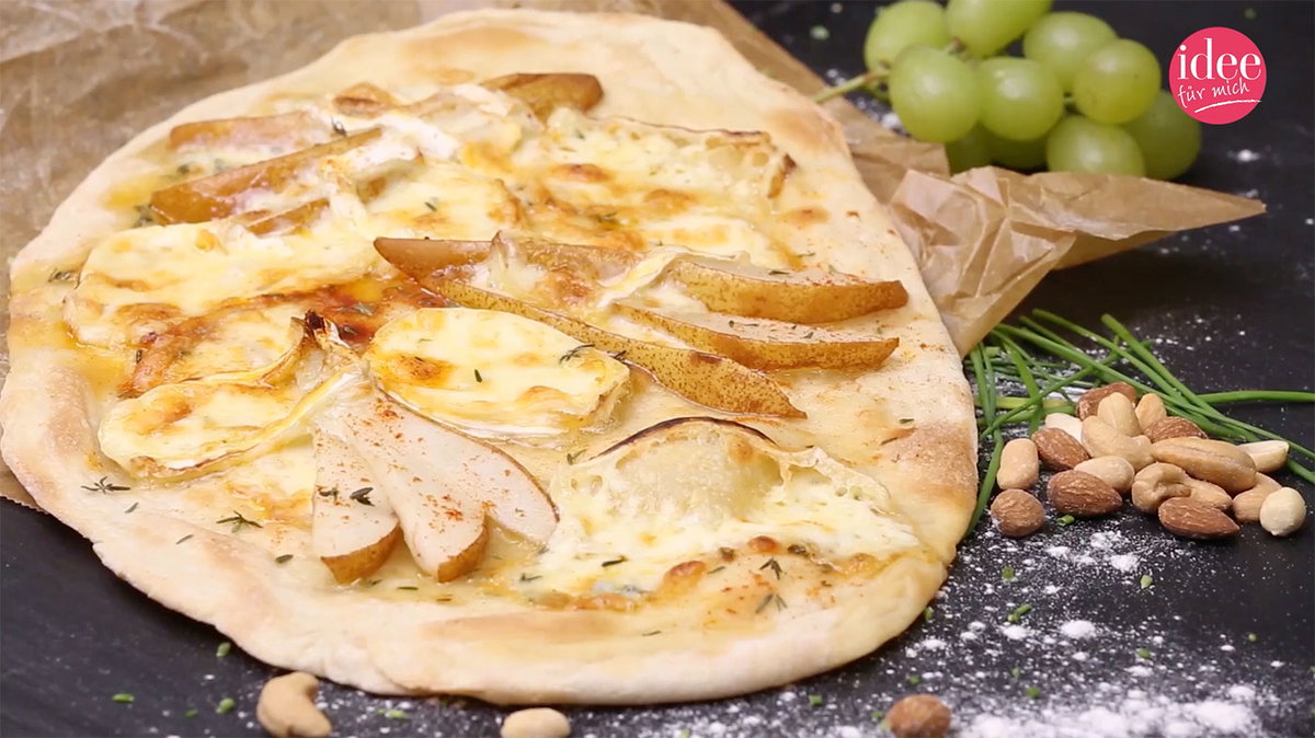 Flammkuchenteig mit Birne und Camembert belegt