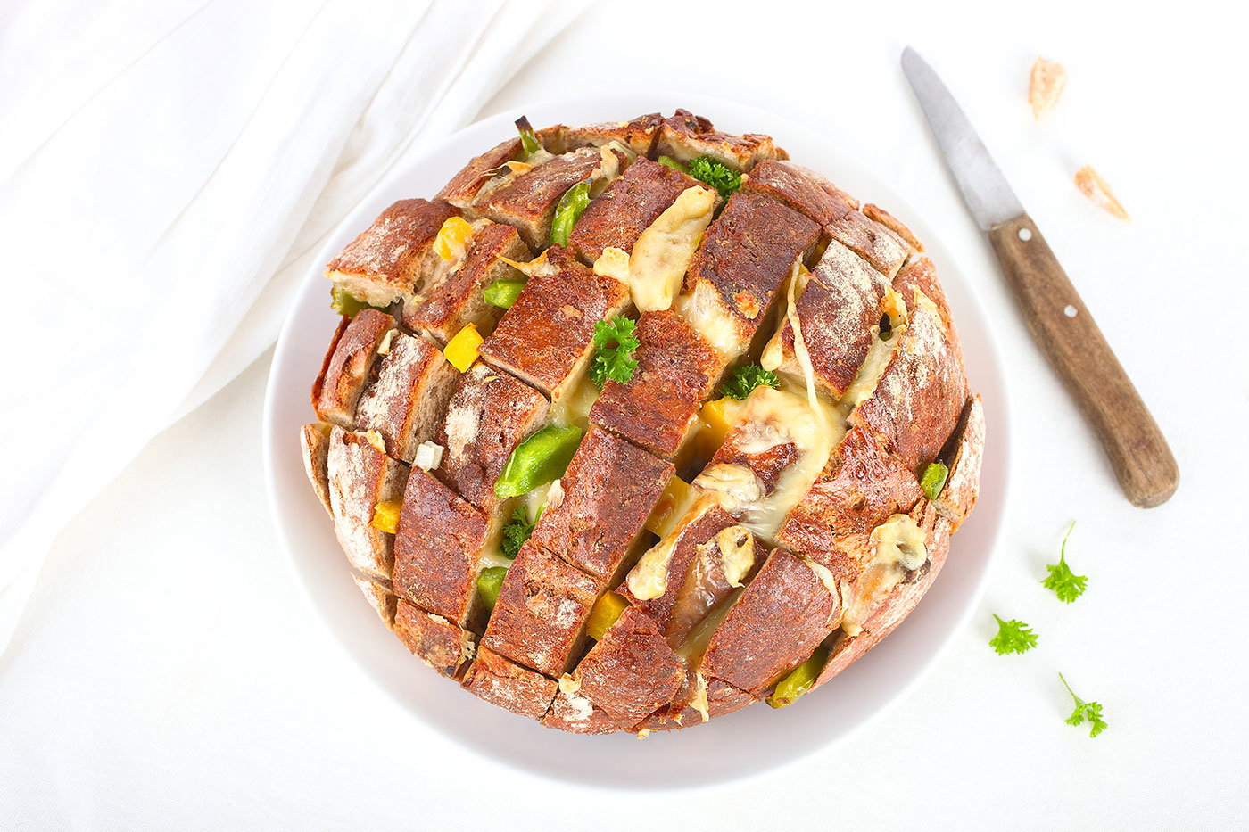 Rezept-Tipp: Zupfbrot mit Kräuterbutter und Käse überbacken